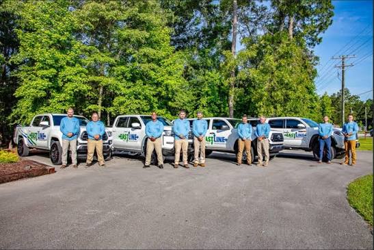 Eastline Pest Management technician team in front of company trucks in New Bern, NC